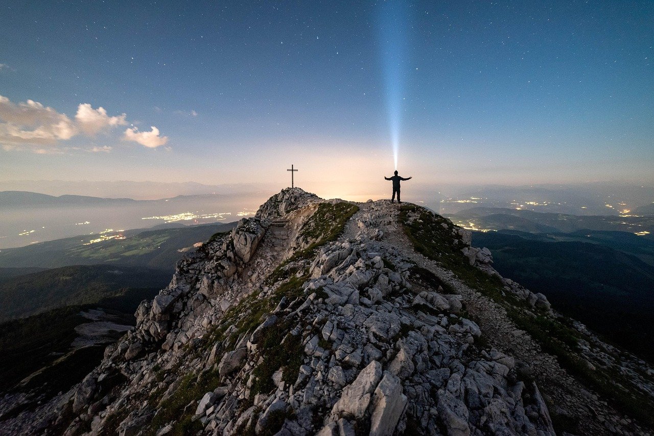 image of a man on top of a mountain with a Cross, symbolizing taking ownership for our spiritual maturity under Christ's headship.
